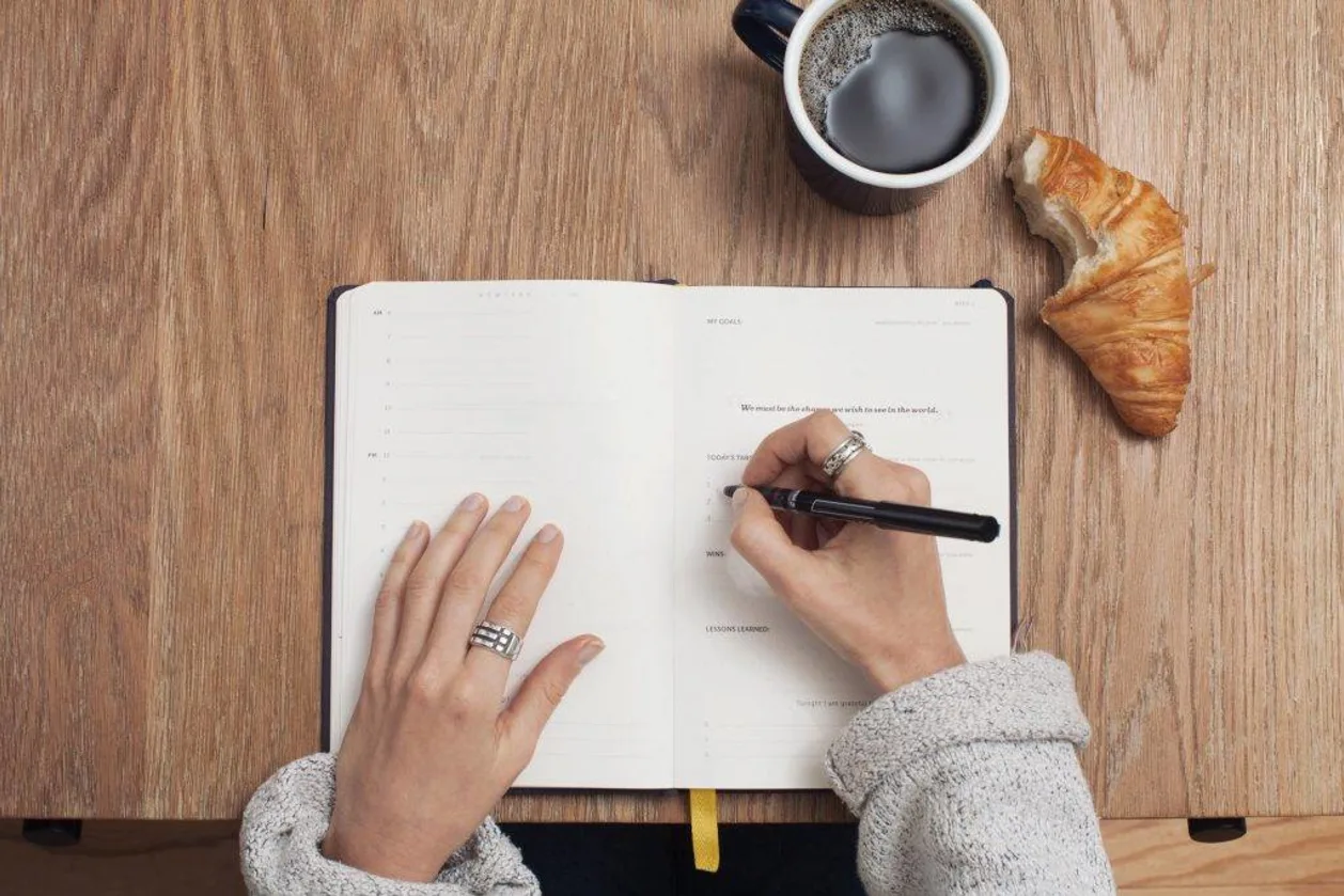 Woman writing in self-improvement journal